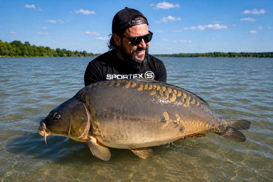 Angler mit Karpfen im See